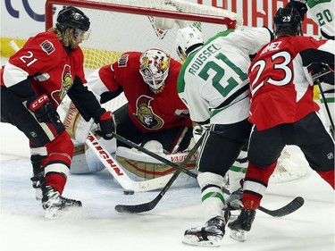 Dallas Stars' Antoine Roussel (21) battles for the puck with Ottawa Senators' goalie Andrew Hammond (30) as Senators' Michael Kostka (21) and Scott Gomez (23) defend during third period NHL hockey action, in Ottawa on Sunday, Mar. 6, 2016. Dallas beat Ottawa 2-1.