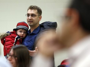 Steve Jaltema holds his two-year-old son, Alexander, while speaking during a meeting at the Jack Purcell Community Centre where parents from Elgin Street Public School gathered to discuss what to do about overcrowding Wednesday February 23, 2016. There were parents of Centennial Public School were also in attendance. At one point the discussion became quite heated after Amir Attaran, a professor at the University of Ottawa faculty at law and medicine, suggested the school board violated it's consultation process through a bait and switch by which they consulted with the public on one proposal but then voted on another.