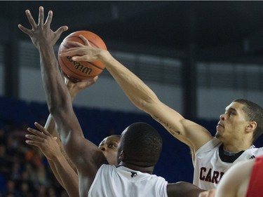 Carleton Ravens' Guillaume Payen Boucard, right, strips the ball from Calgary Dinos' Thomas Cooper as he attempts a shot during CIS men's national university basketball championship final game action in Vancouver, B.C., on Sunday March 20, 2016.