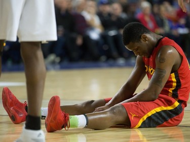 Calgary Dinos' Thomas Cooper sits on the ground after getting called for an offensive foul against the Carleton Ravens during CIS men's national university basketball championship final game action in Vancouver, B.C., on Sunday March 20, 2016.