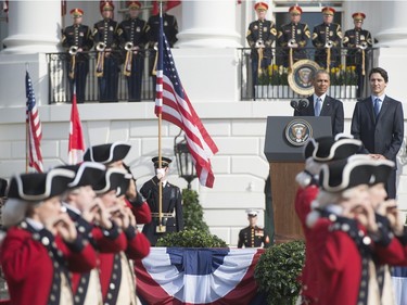 US President Barack Obama stands alongside Canadian Prime Minister Justin Trudeau as they review the troops during a State Arrival ceremony on the South Lawn of the White House in Washington, DC, March 10, 2016. /