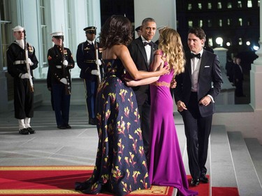 US President Barack Obama (2L) and first lady Michelle Obama (L) greet Canadian Prime Minister Justin Trudeau (R) and Sophie Gregoire-Trudeau (2R) before a state dinner at the White House March 10, 2016 in Washington, DC. /