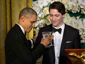US President Barack Obama (L) and Canadian Prime Minister Justin Trudeau  toast during a state dinner at the White House March 10, 2016 in Washington, DC. /