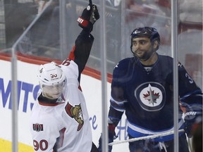 Ottawa Senators' Alex Chiasson (90) celebrates his goal agains the Winnipeg Jets as Jets' Dustin Byfuglien (33) looks on during third period NHL action in Winnipeg on Wednesday, March 30, 2016. The Ottawa Senators were the last club to be eliminated from the Stanley Cup playoffs on Wednesday night, despite beating the Winnipeg Jets 2-1. The Philadelphia Flyers' 2-1 shootout win over the Washington Capitals mathematically eliminated the Sens.