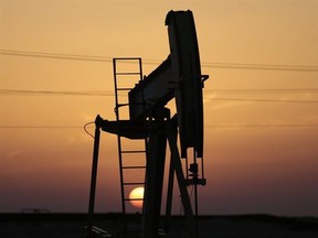An oil pump works at sunset on Saturday, April 16, 2016, in the desert oil fields of Sakhir, Bahrain. Oil-producing countries are to meet in Qatar on Sunday, April 17, 2016, to discuss a plan to freeze output but their gathering comes as nations like Iran rapidly ramp up their pumping. (AP Photo/Hasan Jamali)