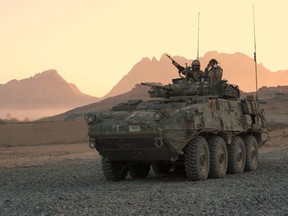In this file photo, a Canadian military light armoured vehicle arrives to escort a convoy at a forward operating base near Panjwaii, Afghanistan at sunrise on Nov.26, 2006.