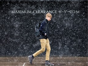 A pedestrian walks along Lisgar Street as the expected snow begins to fall.