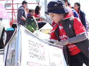 As a kickoff to 'Good Deed Week,' Scouts gathered donated food in a canoe, which they then 'portaged' about four kilometres across the east end to the food bank on Saturday, April 22. Priscilla Hwang, Postmedia