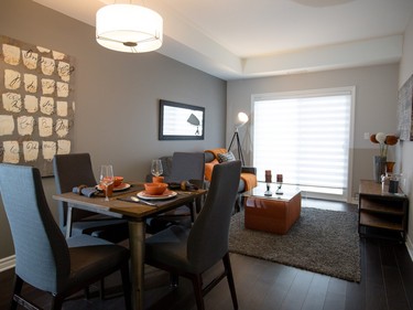 Strong neutrals define the living and dining room of the one-bedroom Avenue model by Brigil at Petrie’s Landing.