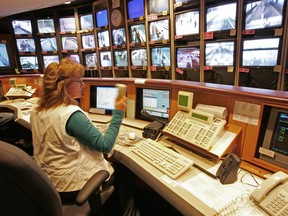 An agent scans transit security cameras. YOU are being watched.