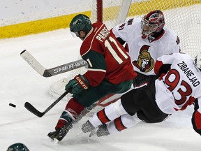 Ottawa Senators' Mika Zibanejad, right, of Sweden, falls as he helps break up a scoring attempt by Minnesota Wild's Zach Parise in the third period of an NHL hockey game Thursday, March 31, 2016, in St. Paul, Minn. The Senators won 3-2. In goal is Craig Anderson.