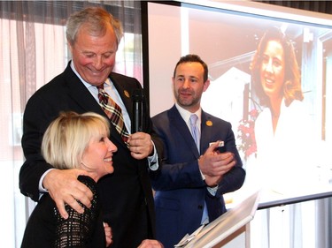 David Lees gives his wife, Lee Ann, a loving squeeze, while standing up at the podium, with their son J.D. Lees.