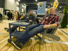 Exhibitors Josh Cooper and Ian Crerar take a break for a cold one on an indoor deck at the Ottawa Cottage and Backyard Show at the EY Centre on Friday.