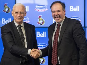 Former Ottawa Senators' General Manager, Bryan Murray, left, shakes hands with the new GM, Pierre Dorion, at a press conference where he announced he's stepping down as general manager of the team but staying on as senior hockey advisor at the Canadian Tire Centre Sunday, April 10, 2016.