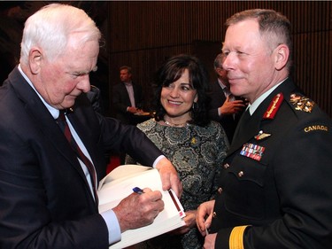 Governor General David Johnston signs a copy of his new book for General Jonathan Vance, Canada's chief of defence staff, and his wife, Kerry Vance, at the book launch of The Idea of Canada: Letters to a Nation, presented by the Ottawa International Writers Festival at the National Arts Centre on Tuesday, April 19, 2016. (Caroline Phillips / Ottawa Citizen)