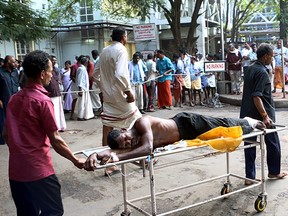 Indian medical officials and bystanders use a trolley to transport an injured man from a vehicle into a hospital in Paravur on April 10, 2016, after an explosion and fire at The Puttingal Devi Temple in the southern Indian state of Kerala. A major explosion and fire swept through a temple in southern India killing in excess of 100 people after families and others had gathered for a fireworks display, a top official said.