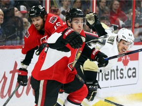 Jean-Gabriel Pageau (L) and Zack Smith of the Ottawa Senators hit Sidney Crosby of the Pittsburgh Penguins during first period of NHL action at Canadian Tire Centre in Ottawa, April 05, 2016.