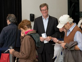 Mayor Jim Watson waits in line to take advantage of an advance poll in the municipal elections in 2014. By 2018, will Ottawa be part of a ranked ballot system?