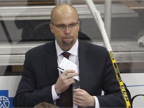 Former Minnesota Wild coach Mike Yeo stands behind his bench during the first period of an NHL hockey game against the Pittsburgh Penguins in Pittsburgh on Tuesday, Jan. 13, 2015.