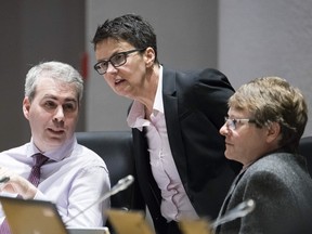 Ottawa city councillors, from left, Riley Brockington, Catherine McKenney and David Chernushenko chat during a meeting to vote on new taxi regulation paving the way for Uber to operate legally in the city at City Hall on Wednesday April 13, 2016.