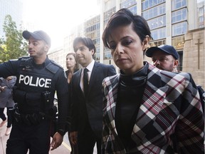 Police escort former CBC radio host Jian Ghomeshi, centre, who appears with his lawyer Marie Henein, right, for his pre-trial hearing for his sexual assault case in Toronto on Thursday, October 1, 2015.