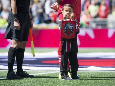 Rafael Alves's son Joao holds a Fury flag while the players walked out on the field. The Ottawa Fury FC host the Miami FC for the Fury's home-opener Saturday April 30, 2016 at TD Place.   Ashley Fraser