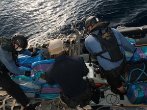 Sailors from Her Majesty's Canadian Ship (HMCS) EDMONTON and a United States Coast Guard Law Enforcement Detachment member (center) gather several packages that were recovered after being thrown overboard from a vessel of interest during Operation CARIBBE on March 25, 2016.

Photo: OP Caribbe, DND
ET2016-4049-22
~
Des marins du Navire canadien de Sa Majesté (NCSM) EDMONTON et un membre du détachement d’application de la loi de la Garde côtière américaine (au centre) rassemblent plusieurs sacs qui ont été récupérés après avoir été jetés par dessus bord depuis un navire d’intérêt au cours de l’opération CARIBBE, le 25 mars 2016.

Photo : OP Caribbe, MDN
ET2016-4049-22