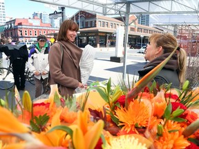 Renowned New York City transportation and public space guru Janette Sadik-Khan visits the ByWard Market as part of a stop in Ottawa, April 27, 2016.  She is seen buying flowers from Chantal Brazeau.