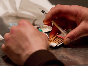 A man prepares heroin to be injected at the Insite safe injection clinic in Vancouver, B.C., on Wednesday May 11, 2011. Ottawa and Toronto are joining the growing list of Canadian cities - which includes Ottawa and Montreal - that plan to set up safe-injection sites.