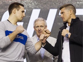 Rory MacDonald, left, and Stephen Thompson  square up for the cameras, while Tom Wright, UFC executive vice-president and general manager for Canada, Australia and New Zealand, center, looks on during a media availability for the June 18th UFC Fight Night match between MacDonald and Thompson at TD Place Monday April 11, 2016.