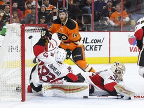 The Flyers' Sean Couturier shoots the puck over the Ottawa Senators' Mika Zibanejad and goalie Andrew Hammond for a power-play goal during the second period of an NHL hockey game Saturday, April 2, 2016, in Philadelphia.
