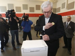 Manitoba NDP Leader and Premier Greg Selinger applies an "I Voted" button after voting in the provincial election in Winnipeg, Tuesday, April 19, 2016.