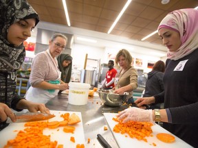 Syrian refugee Hiba Chakif, right, and her daughters Rana and Mallak prepare ingredients at a Soup for Syrians event in Calgary in January.
