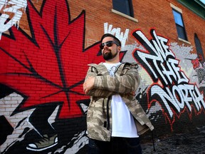 Artist Phil Laporte poses for a photo in front of his mural at 792 Bank Street in Ottawa.