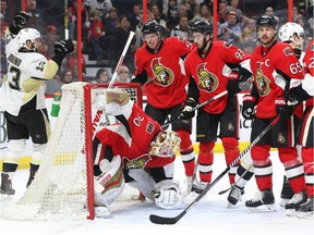 The Ottawa Senators look on dejected as Nick Bonino (L) of the Pittsburgh Penguins celebrates his team's goal during second period of NHL action at Canadian Tire Centre in Ottawa, April 05, 2016.