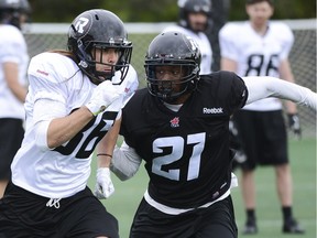 Wide receiver Robin Medeiros (L) runs past defensive back Eddie Elder (R) during the Ottawa Redblacks rookie camp in 2014.