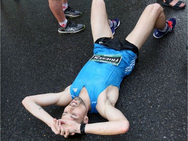 Canadian Kevin Friesen lies on the ground after crossing the finish line of the Ottawa 10K run.