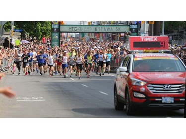 The pace car leads the start of the first wave during the 5K run.