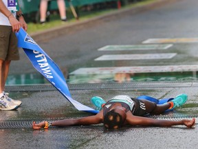 Peres Jepchirchir of Kenya lies flat on her back after collapsing as she crossed the finish line to win the Tamarack Ottawa Race Weekend 10K on Saturday, May 28, 2016.