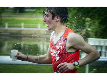 A runner throws water on himself to cool down during the 10K.