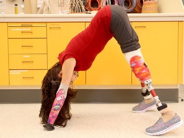 A special prosthetic made for her left arm allowed Christine to get back to yoga. She demonstrates her "downward dog" at the Ottawa Hospital's rehab centre, May 5, 2016.