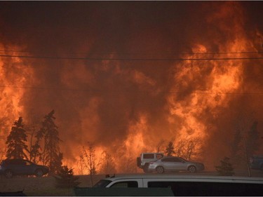 A wall of fire rages outside of Fort McMurray, Alta. Tuesday May 3, 2016. Raging forest fires whipped up by shifting winds sliced through the middle of the remote oilsands hub city of Fort McMurray Tuesday, sending tens of thousands fleeing in both directions and prompting the evacuation of the entire city.