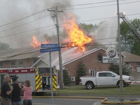 Cornwall residents watch as firefighters battle a blaze at the Ontario Hockey Academy Thursday evening.