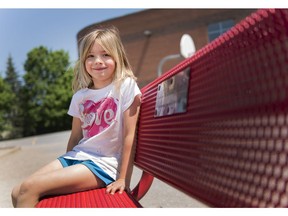 Ava Thorsell, 7, sits on the buddy bench placed at A. Lorne Cassidy Elementary School. Children in need of a friend at recess can sit there until someone asks them to play.