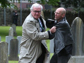 Canadian Ambassador to Ireland Kevin Vickers, left, wrestles with a protester during a State ceremony to remember the British soldiers who died during the Easter Rising at Grangegorman Military Cemetery, Dublin Thursday May 26, 2016.
