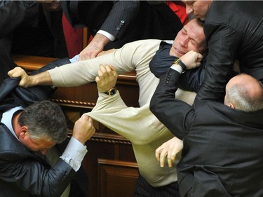 Deputies of Ukraine's parliament fight during a parliament sitting in Kiev on April 27,  2010. Fighting broke out and smoke bombs and eggs were thrown Tuesday as Ukraine's parliament erupted into chaos as it ratified a bitterly controversial deal with Russia extending the lease of a key naval base. The deal signed last week by Russian President Dmitry Medvedev and his Ukrainian counterpart Viktor Yanukovych had been slammed by the pro-Western Ukrainian opposition as a historic surrender of sovereignty.