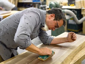Andrew Morel sands a piece of walnut that he’ll turn into a coffee table at Ottawa City Woodshop, an industrial space located inside Makerspace North at City Centre.