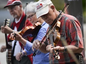 Fiddlers perform together at Marion Dewar plaza to celebrate the National Fiddling Day as the city of Ottawa also recognize the fiddling day on Saturday, May 21, 2016. (James Park)