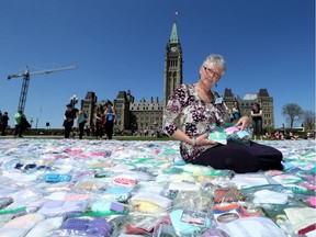 Fiena Dykstra sits amidst 6,980 pairs of baby booties as part of a Pro Life rally on Parliament Hill.