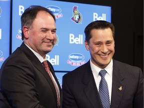Newly-named head coach for the NHL's Ottawa Senators, Guy Boucher (right) shakes hands with team general manager Pierre Dorion after a news conference in Ottawa, Monday, May 9, 2016.